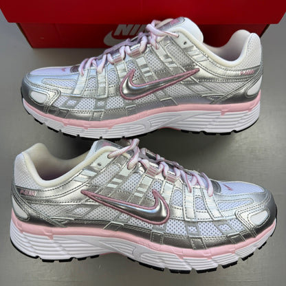 Nike white trainers with elemental pink and silver accents, featuring logo details.