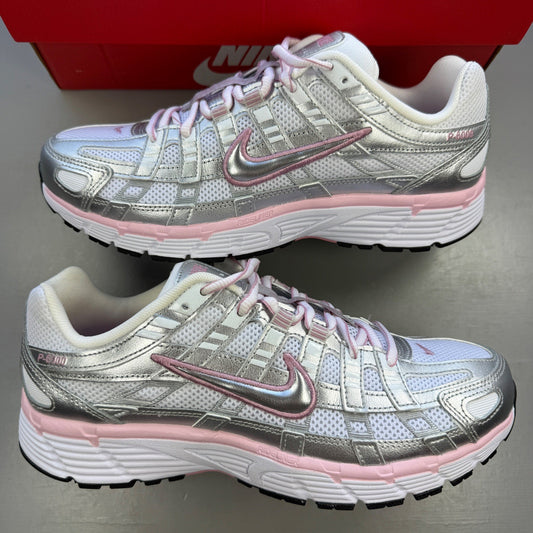 Nike white trainers with elemental pink and silver accents, featuring logo details.