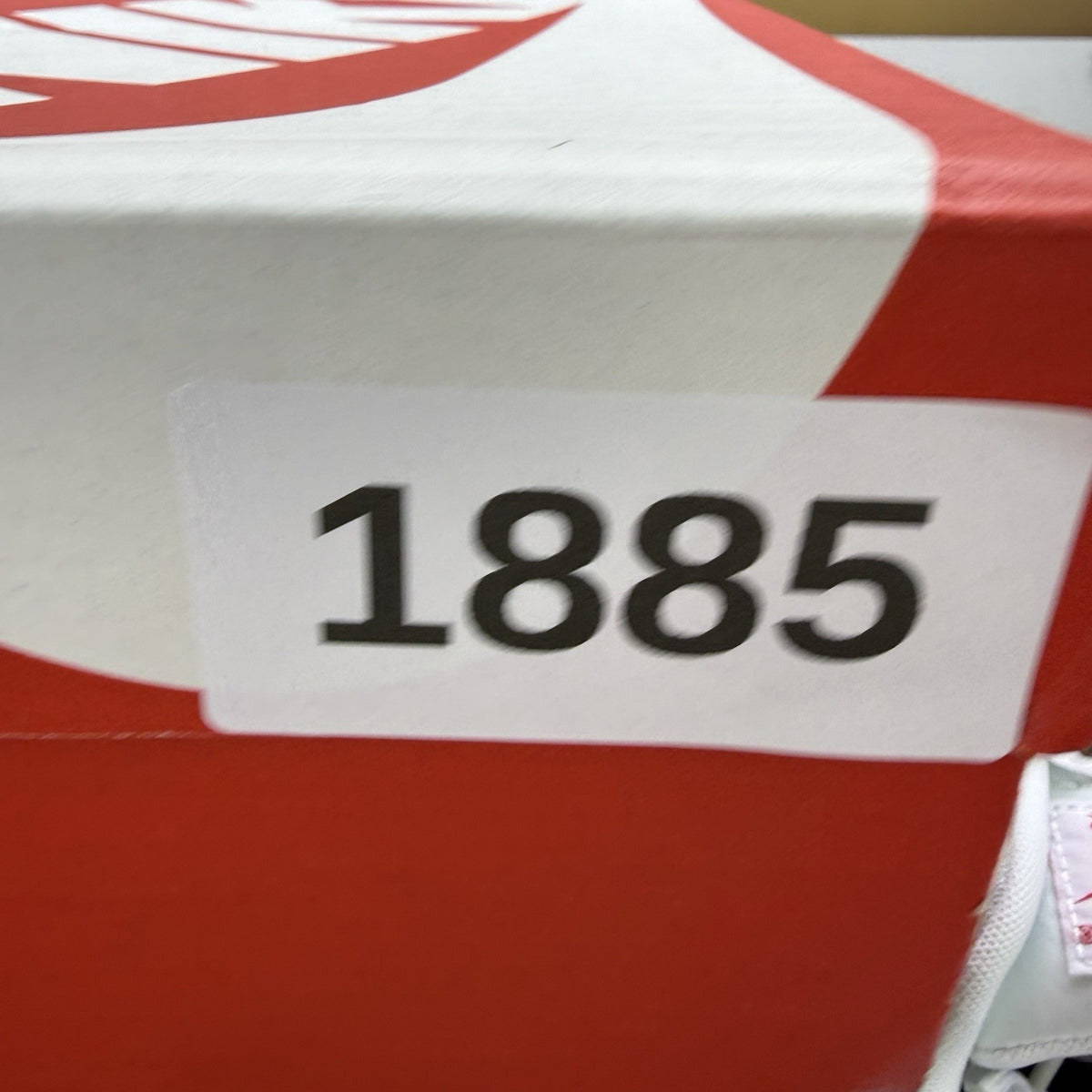 Nike Air Max 90 white trainers with black and red accents, featuring iconic logo and design.