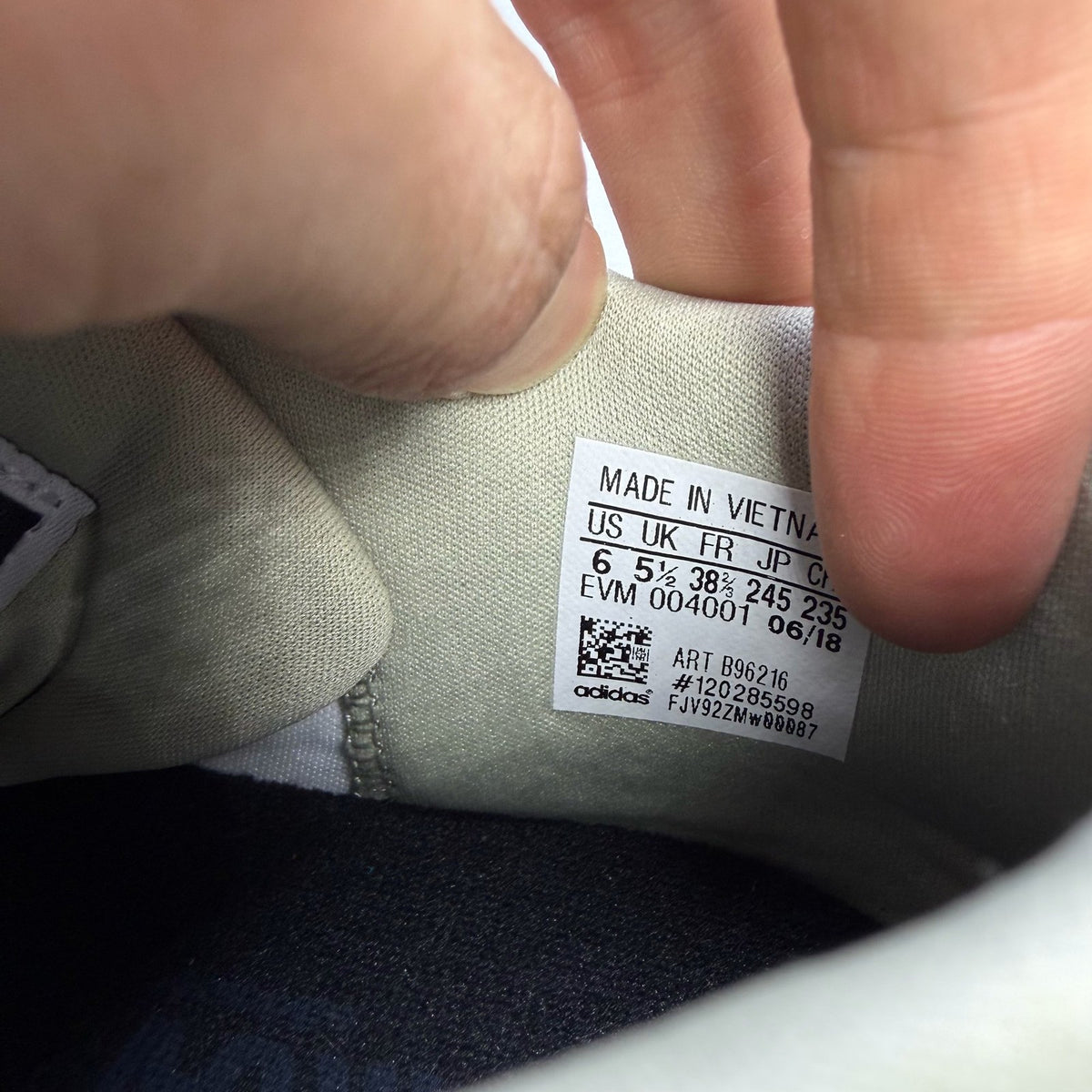 Adidas grey trainers with textured upper and distinctive three-stripe logo detail.