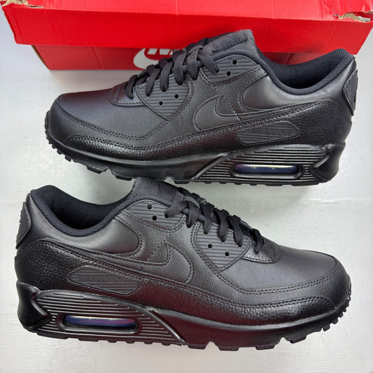 Nike Air Max 90 black leather trainers with logo detailing and textured upper.