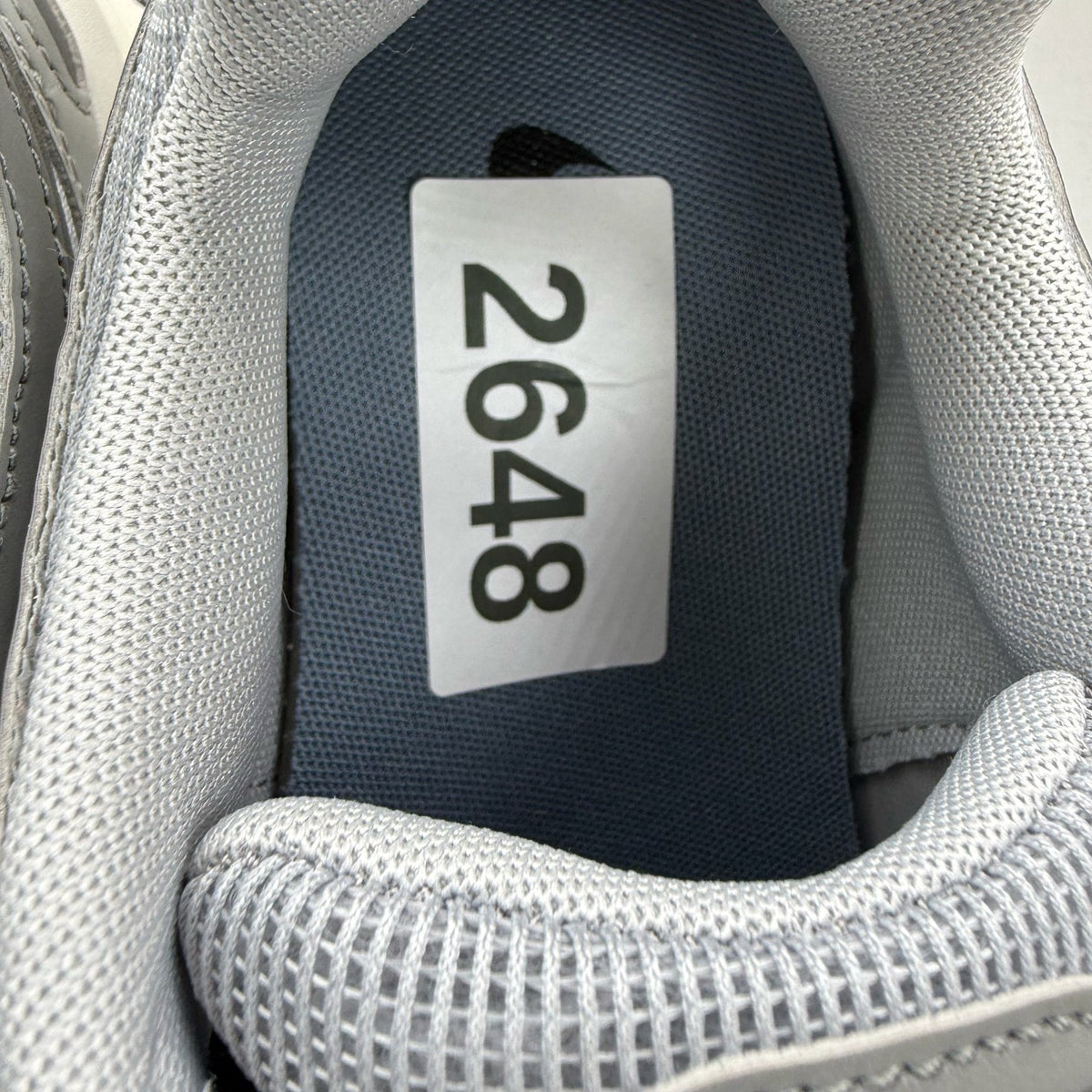 Nike grey trainers with blue accents and mesh material, featuring iconic swoosh logo.