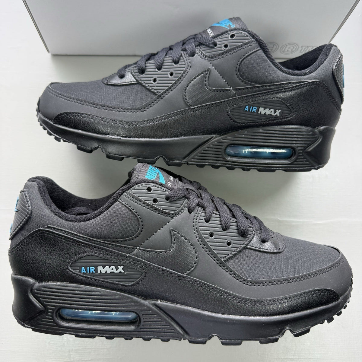 Nike Air Max 90 black trainers with laser blue accents and signature logo.