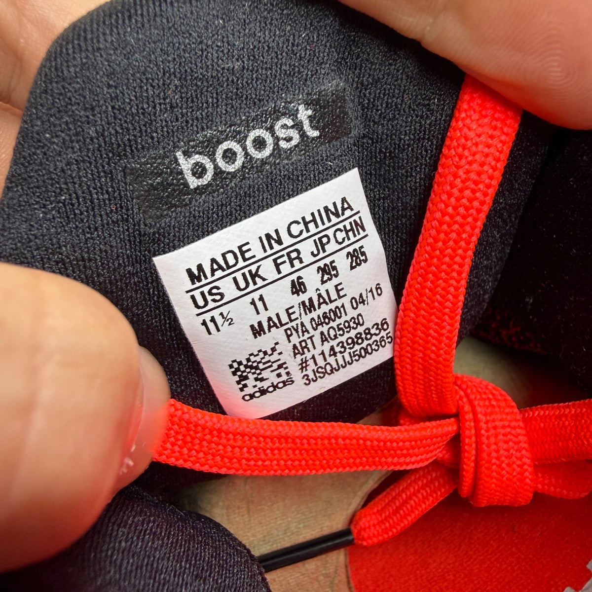 Adidas Ultra Boost 2.0 red trainers with black accents and signature three-stripe logo.