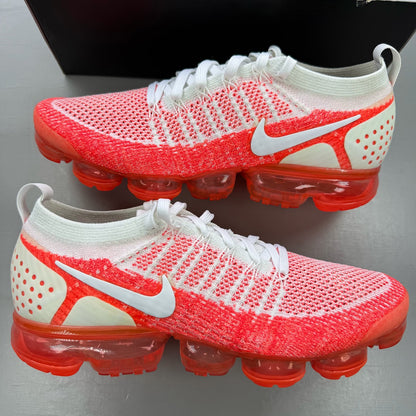 Nike Air VaporMax 2 Flyknit white trainers with hot punch red accents and breathable material.