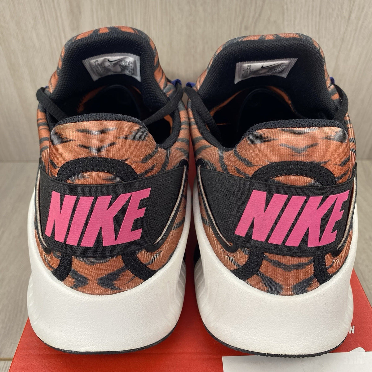 Nike Free Metcon 4 trainers black with tiger burnt sunrise accents and logo detail.