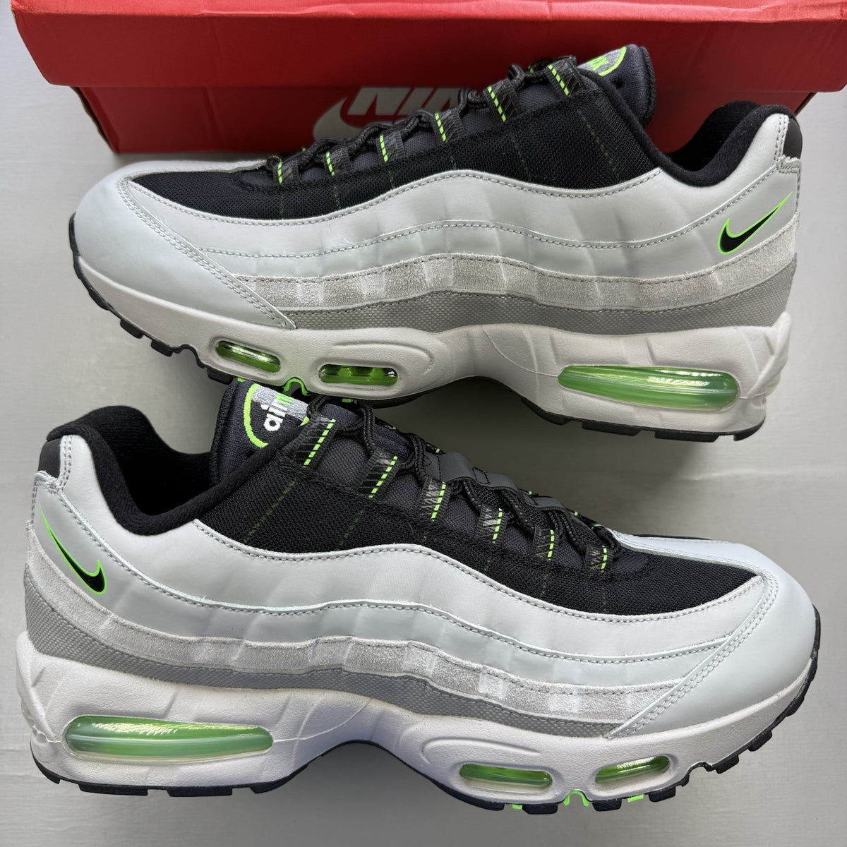 Nike Air Max 95 trainers black with grey and green accents, featuring signature logo.