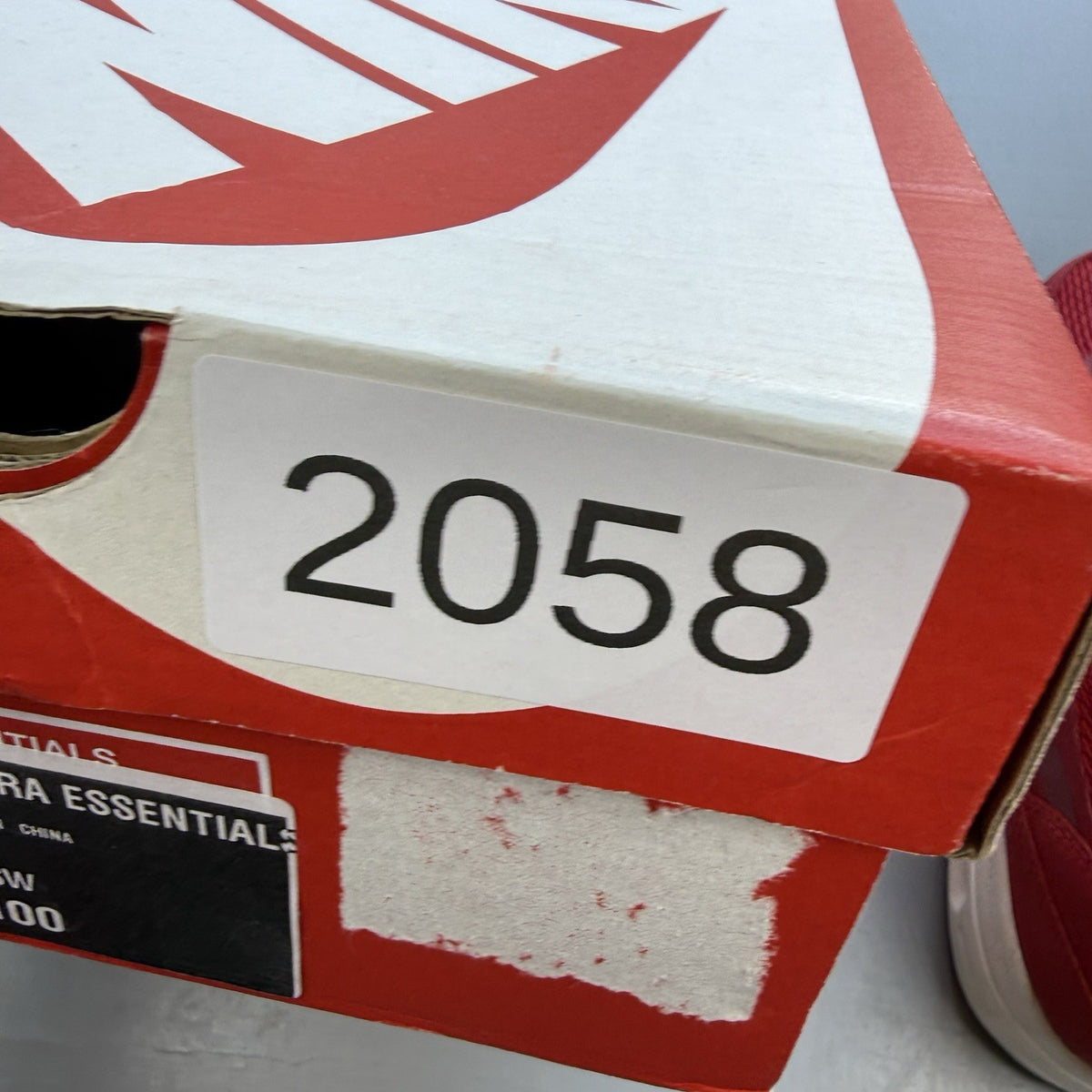 Nike Air Max 1 Ultra Essential red trainers with white and black accents, logo detail.
