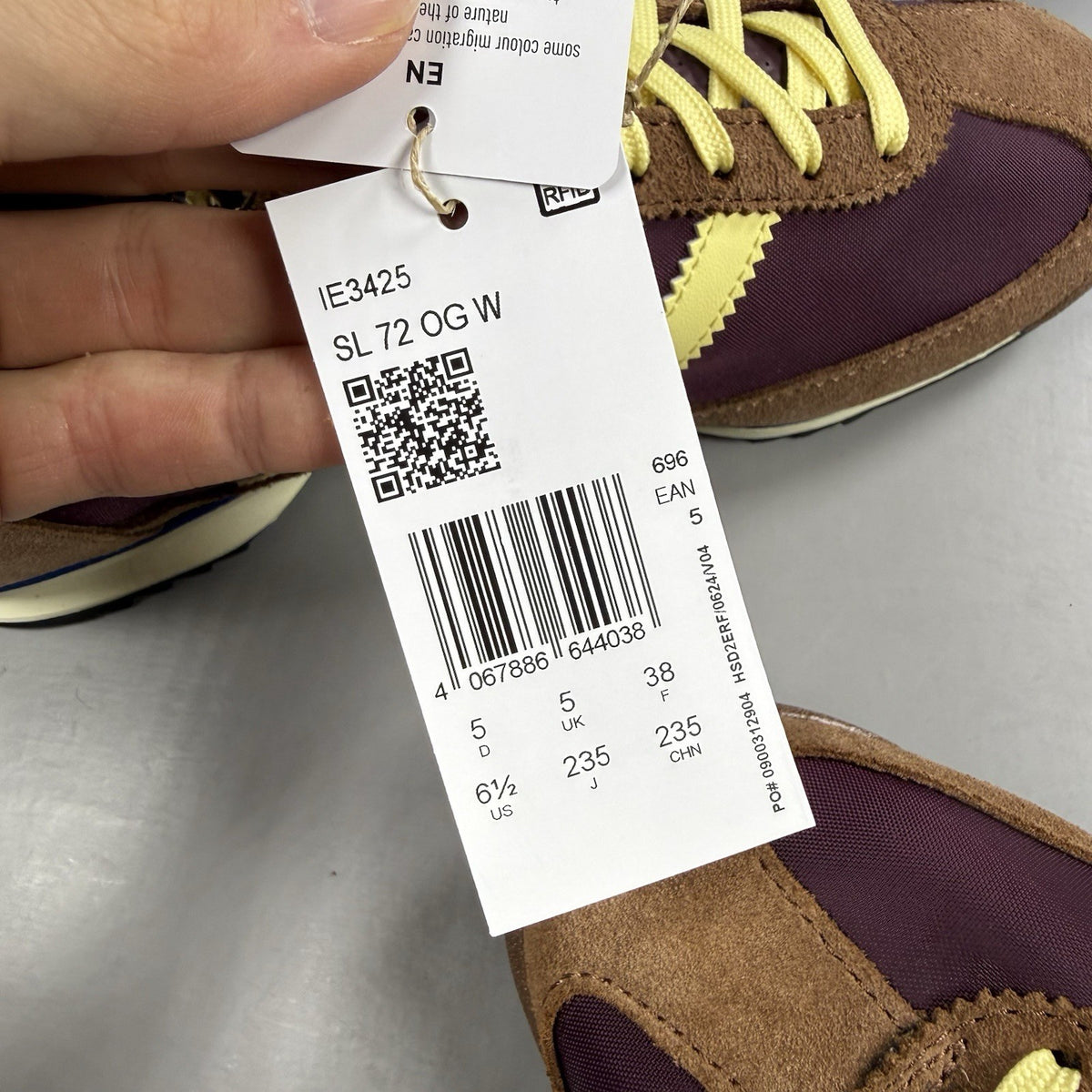 Adidas brown trainers with retro design and classic logo detail.