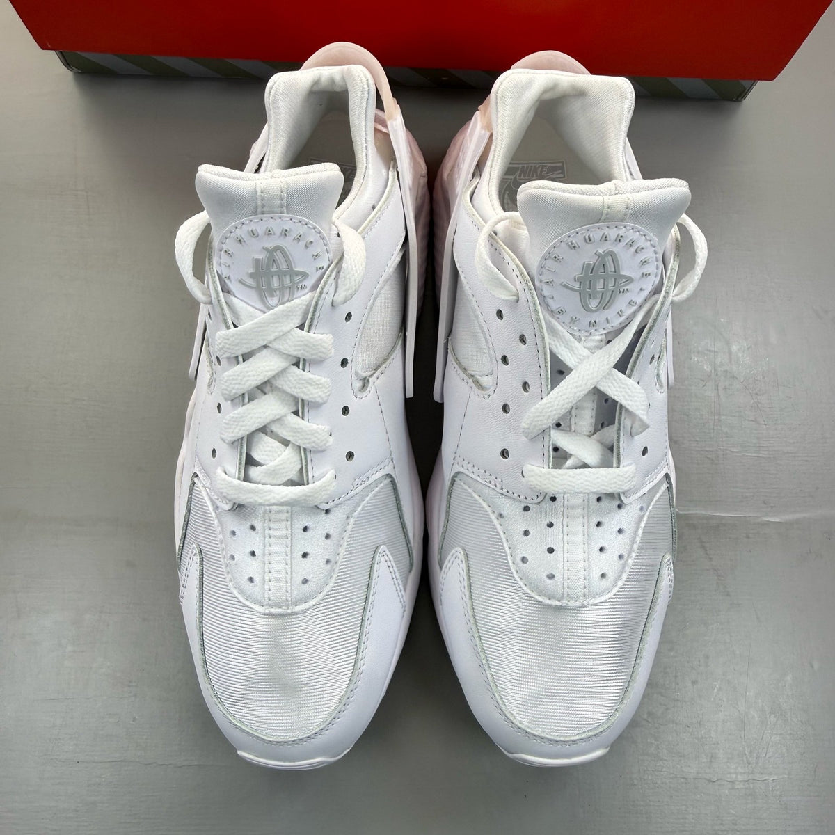 Nike Air Huarache white trainers with textured upper and signature logo detail.