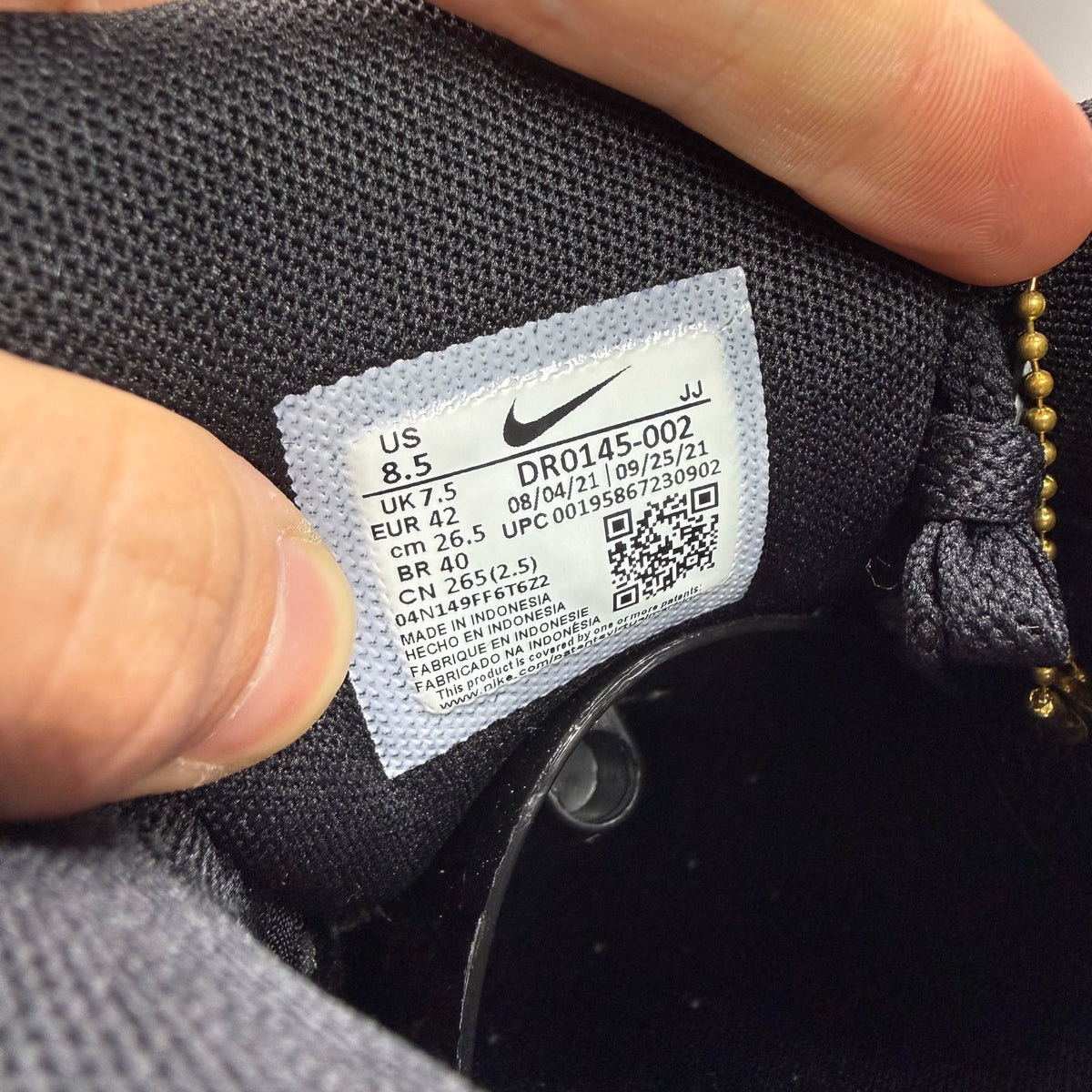 Nike Air Max 90 black trainers with grey accents and logo detail.