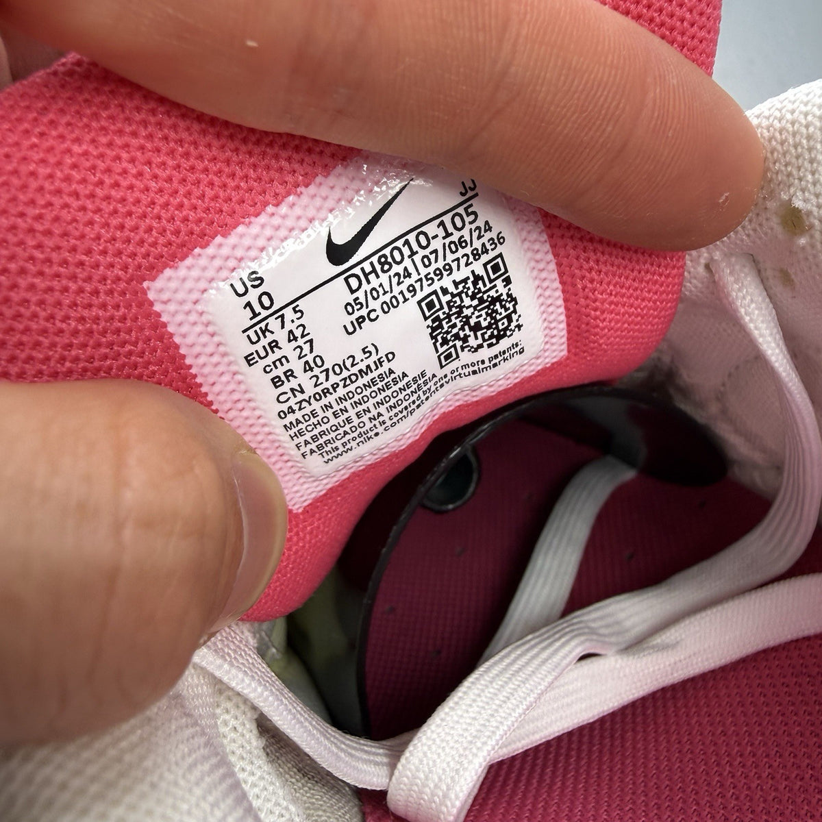 Nike Air Max 90 trainers white with pink and black accents, featuring logo details.