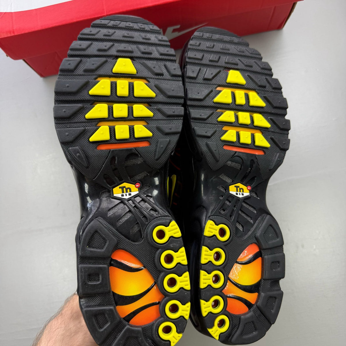 Nike black trainers with Tuned Air technology and sunrise pattern accents.