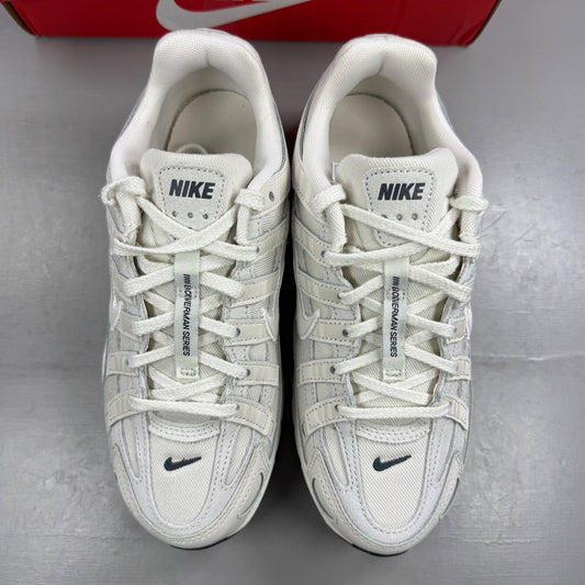 Nike beige athletic shoes with white accents and light bone detailing.
