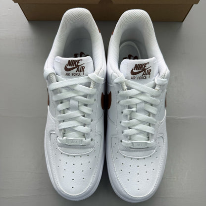 Nike Air Force 1 trainers white with brown accents and signature logo detail.