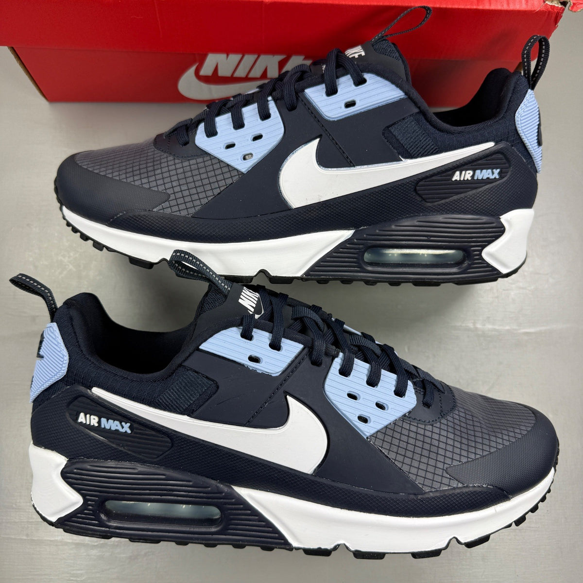 Nike Air Max 90 blue trainers with dark obsidian accents and signature swoosh logo.