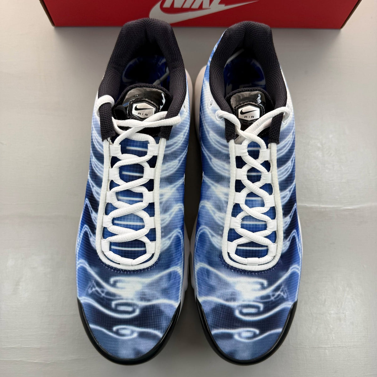 Nike Air Max Plus TN blue trainers with distinctive wave pattern and logo.