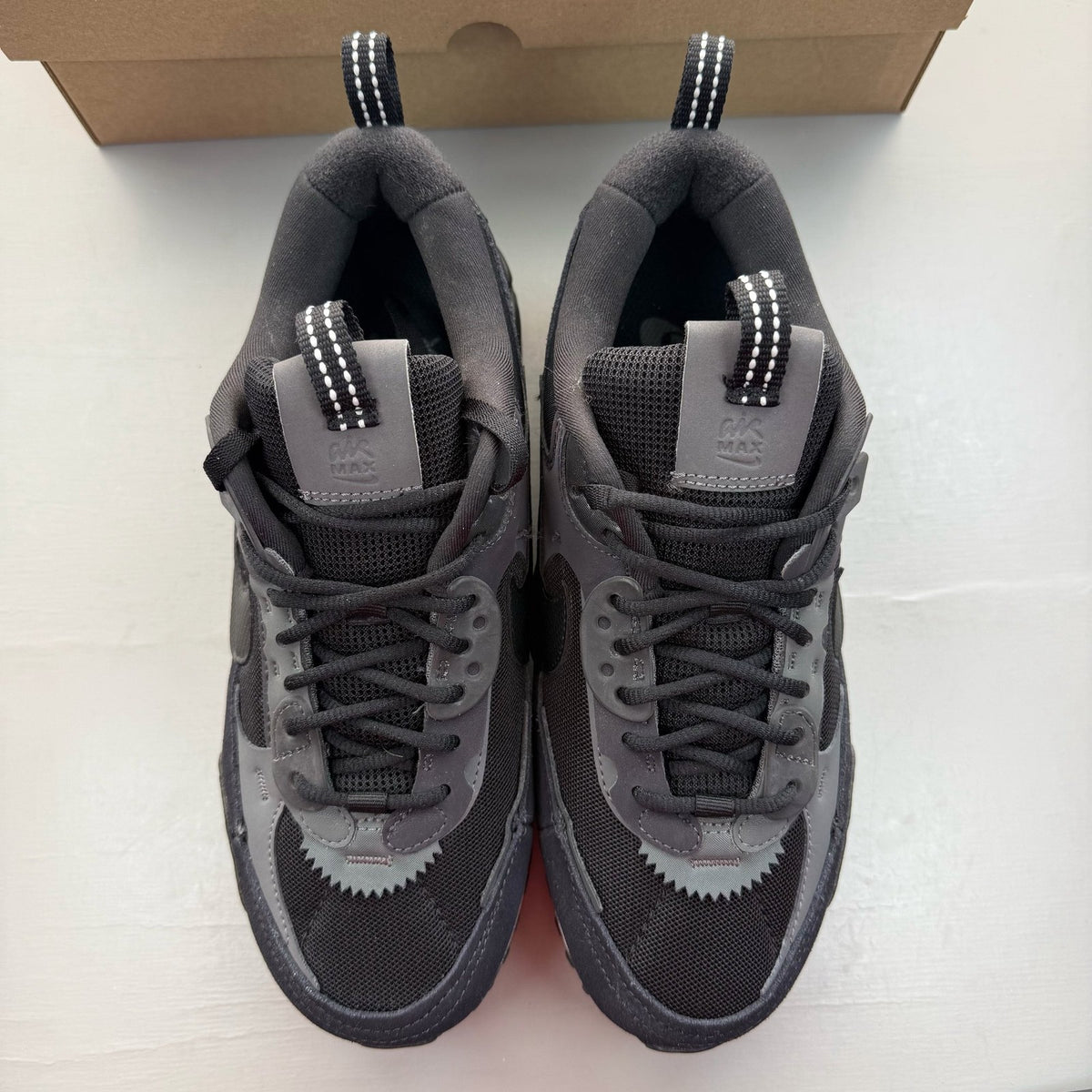 Nike black Air Max 90 Futura trainers with grey accents and logo detail.