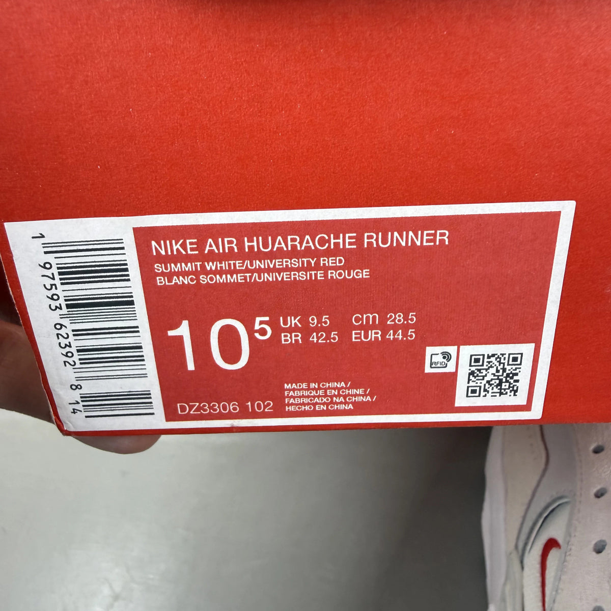 Nike Air Huarache Runner white trainers with red accents and signature logo.