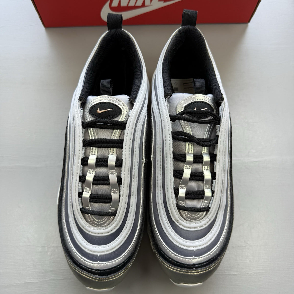 Nike Air Max 97 SE metallic silver trainers with bronze accents and white sole.