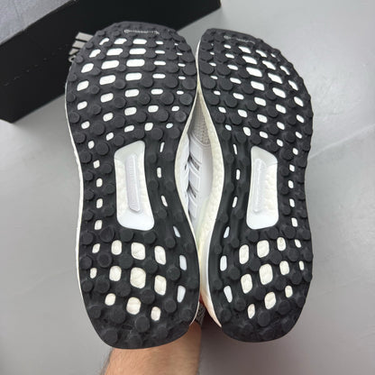 Adidas Ultra Boost 4.0 DNA white trainers with black accents and signature three-stripe logo.