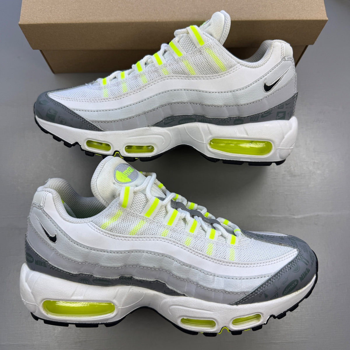 Nike trainers white with neon grey volt accents and retro logo details.