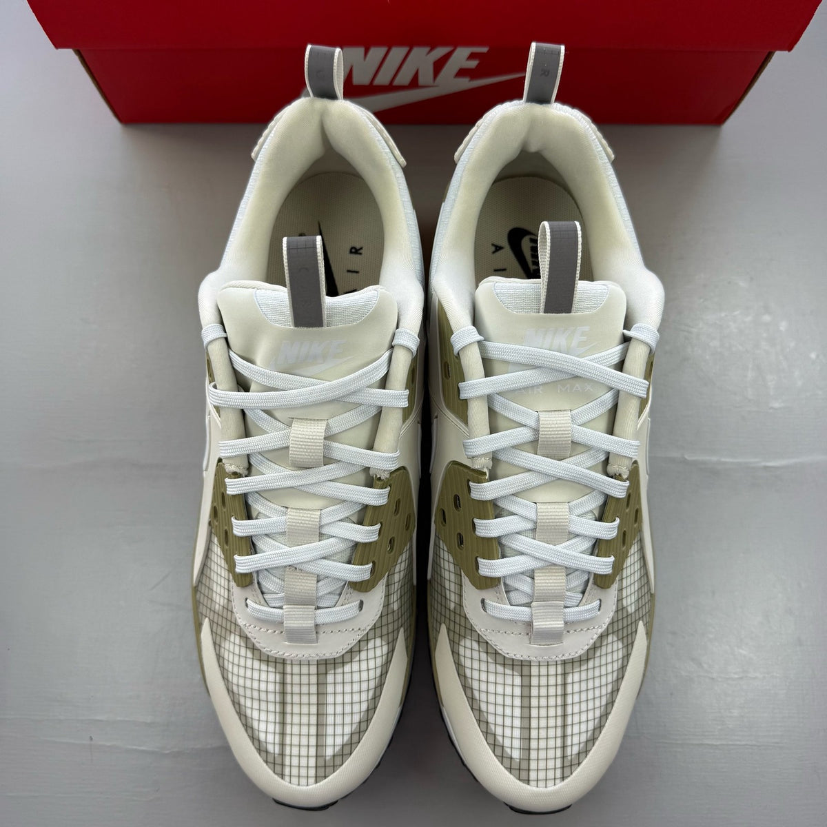 Nike Air Max 90 beige trainers with swoosh logo and mesh detailing.