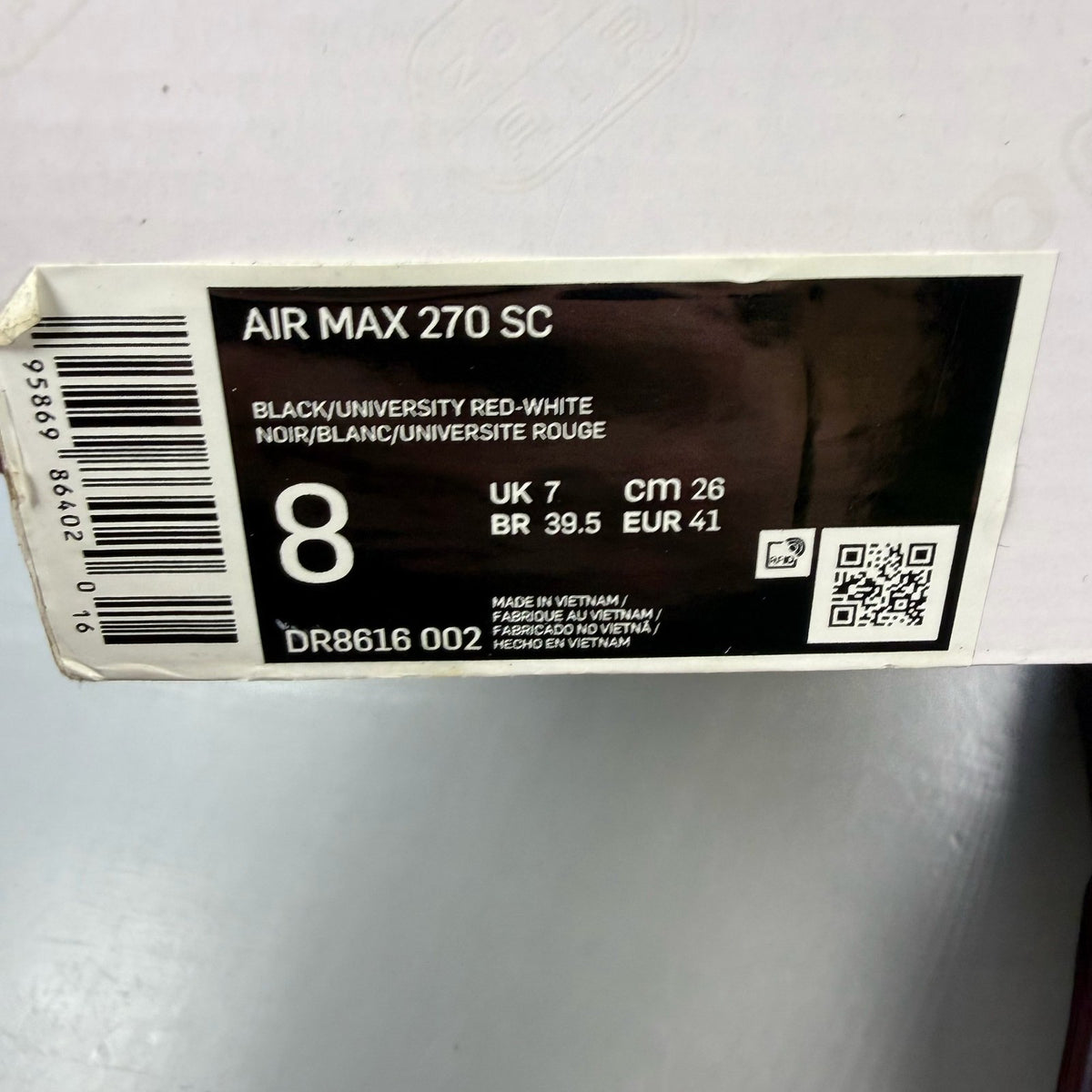 Nike Air Max 270 black trainers with university red accents and white sole.