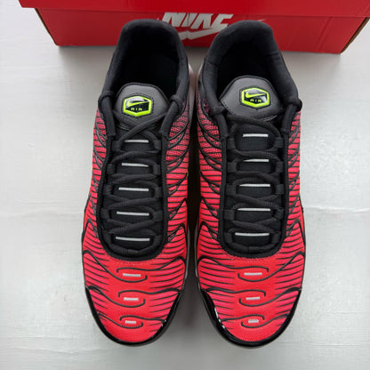 Nike Air Max Plus TN black trainers with light crimson and volt accents, logo on tongue.