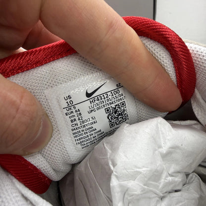 Nike Air Max 1 white trainers with red accents and classic logo detailing.