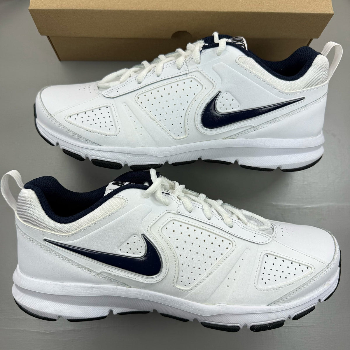 Nike white running trainers with black and navy accents, featuring logo details.