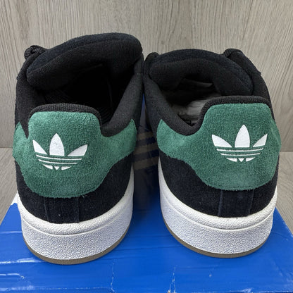 Adidas black trainers with yellow accents and classic three-stripe logo design.