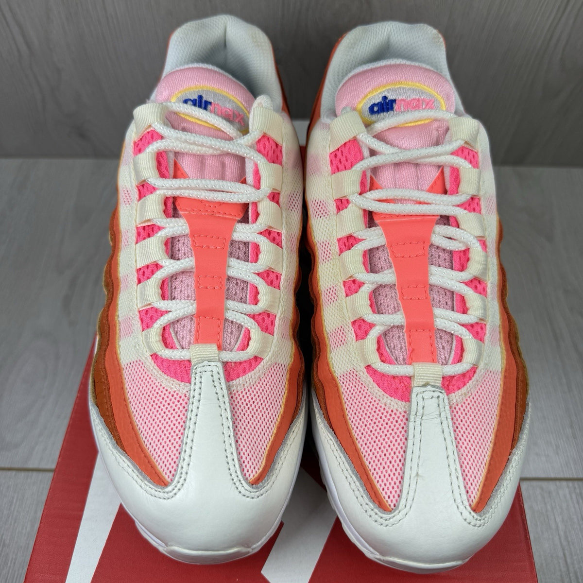 Nike Air Max 95 trainers white with campfire orange accents and signature logo details.