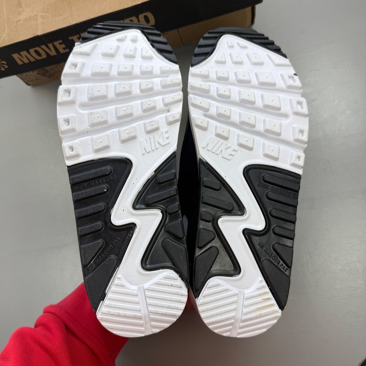 Nike Air Max 90 white athletic shoes featuring double swoosh logo and sleek design.