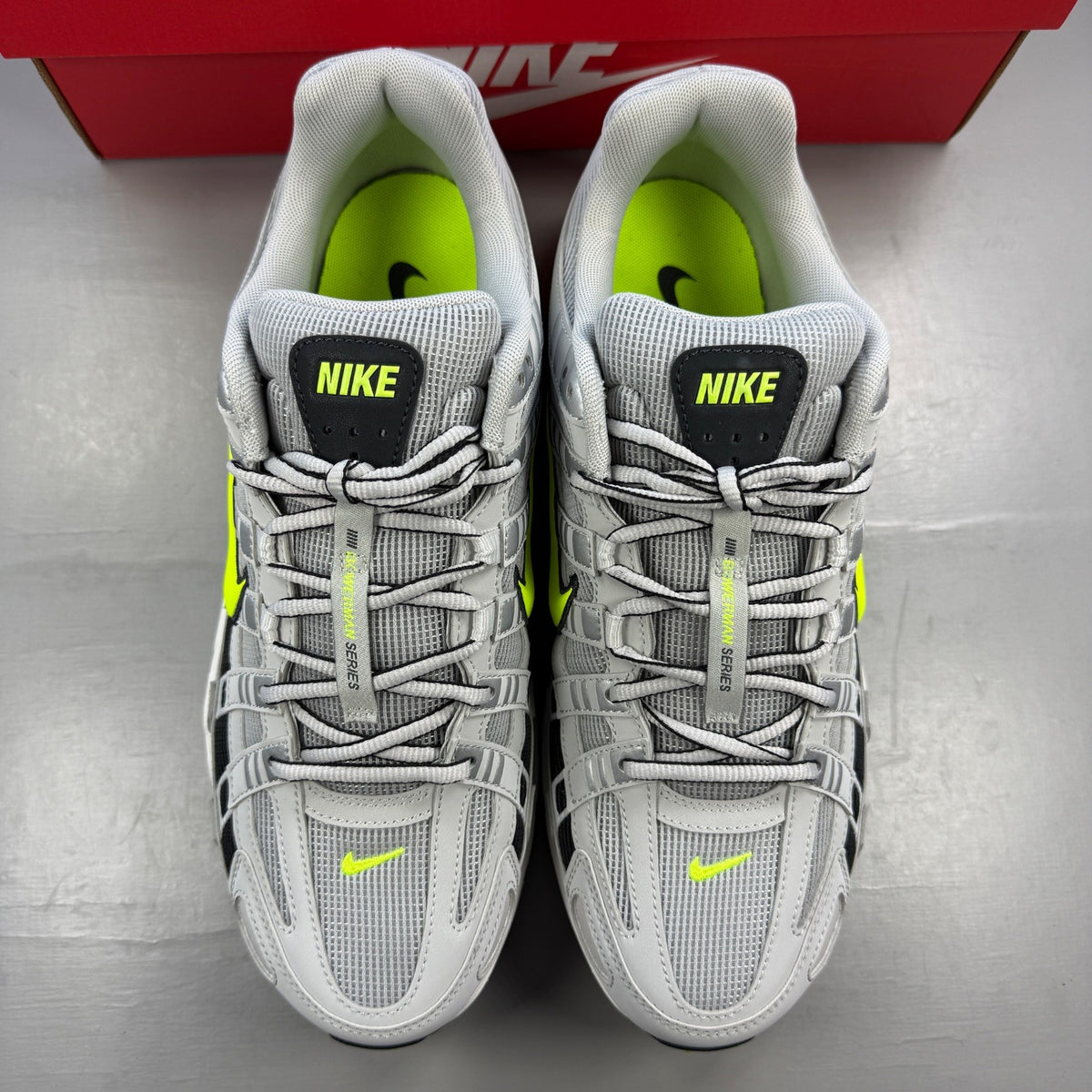 Nike athletic shoes grey with black and volt accents, mesh upper and logo detail.
