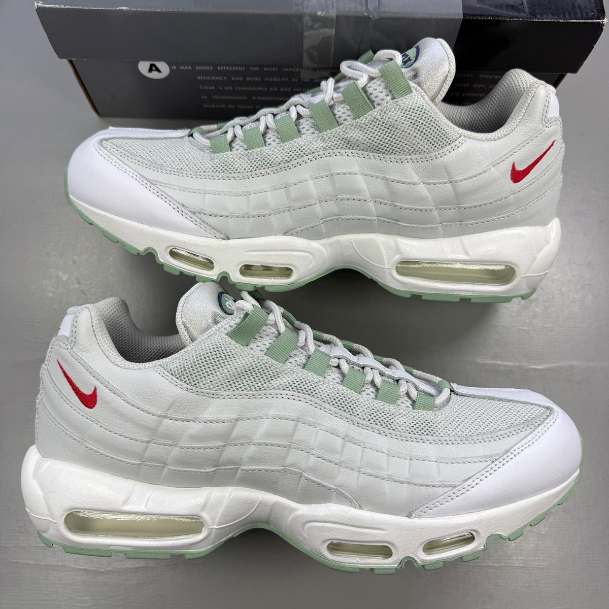 Nike running shoes white with green accents and distinctive Air Max cushioning.
