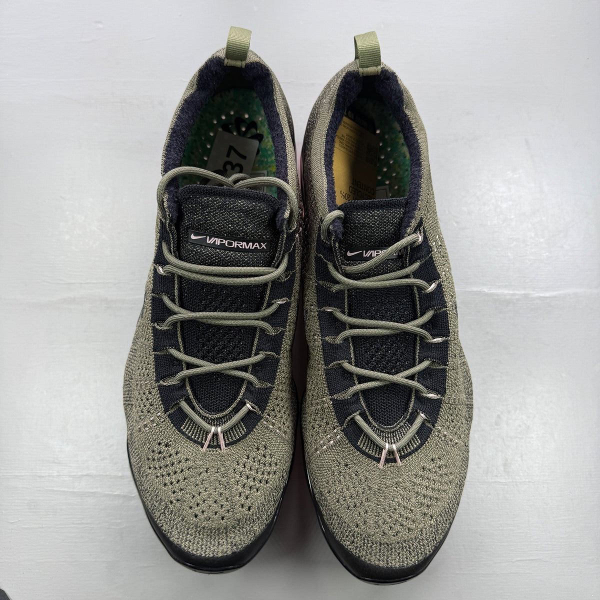Nike trainers green Flyknit upper with pink accents and Air cushioning.