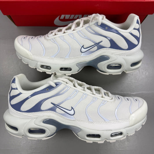 Nike white athletic shoes with Air Max Plus TN design and visible logo details.