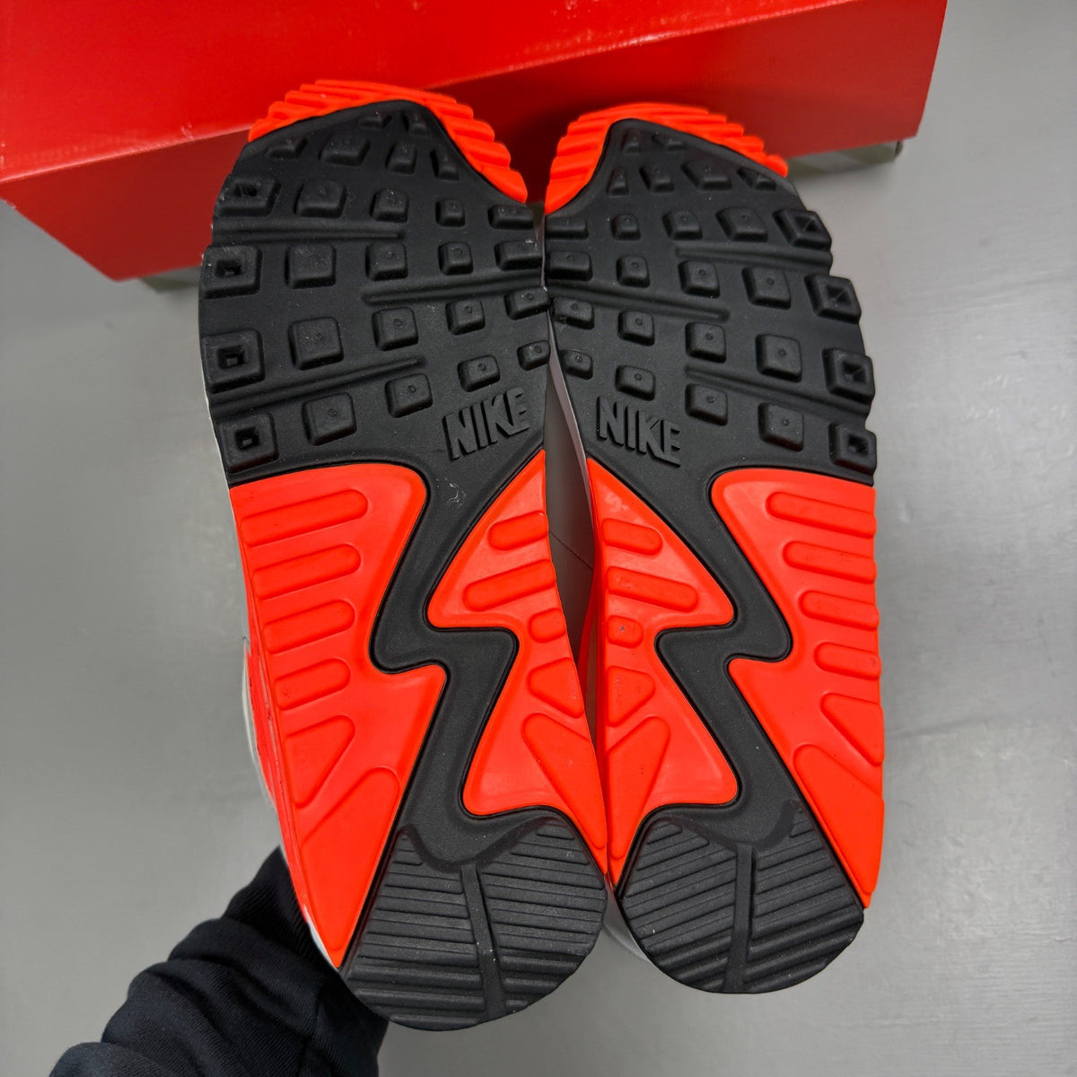 Nike trainers white with hyper orange accents and grey detailing, featuring iconic swoosh logo.