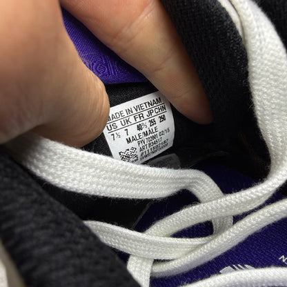 Adidas ZX Flux white trainers with purple and black accents, featuring iconic three-stripe logo.