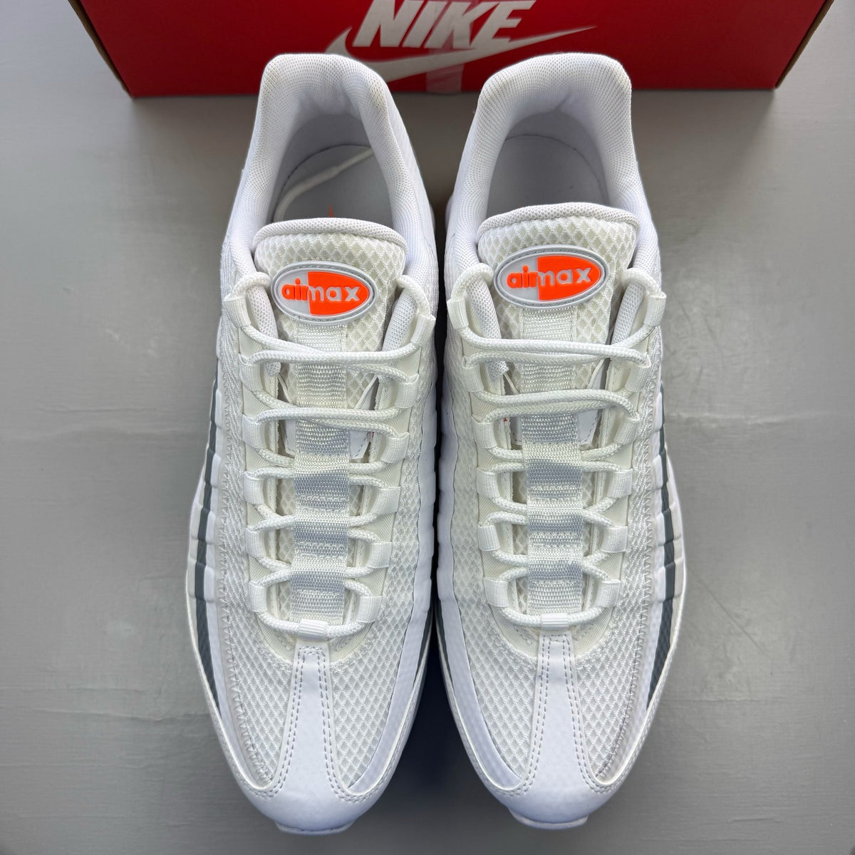 Nike Air Max 95 white trainers with grey accents and signature swoosh logo.