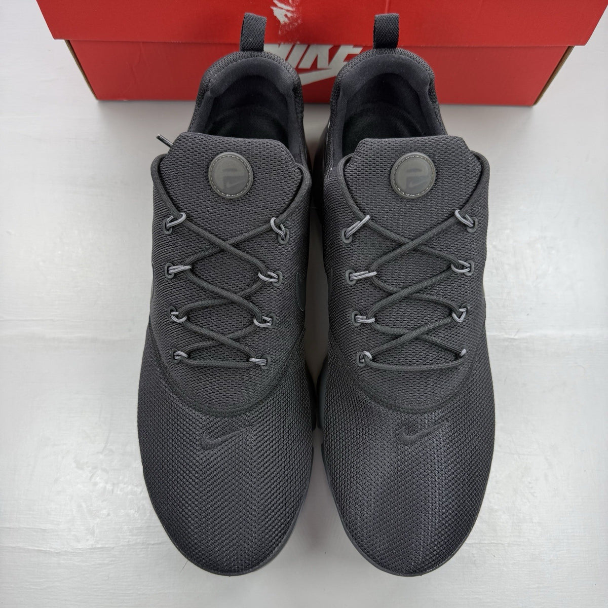 Nike Presto Fly black trainers with dark grey accents and logo detail.