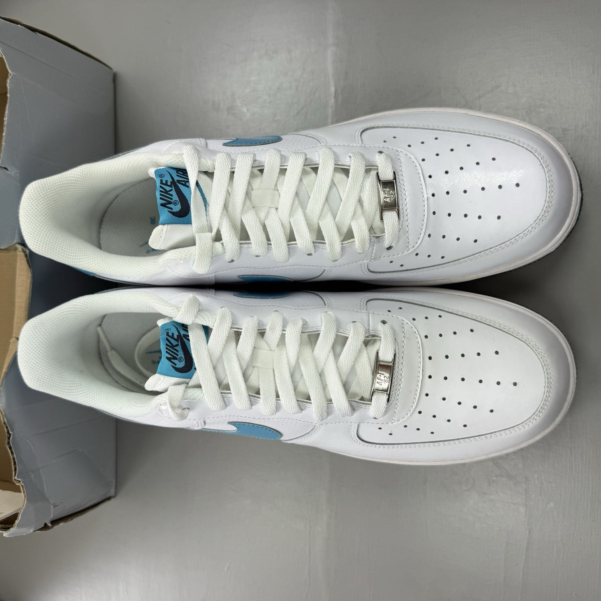 Nike Air Force 1 trainers white with marina blue and dark obsidian accents.