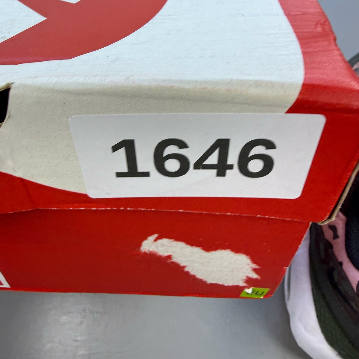 Nike black trainers with pink camo accents and white sole, featuring logo details.