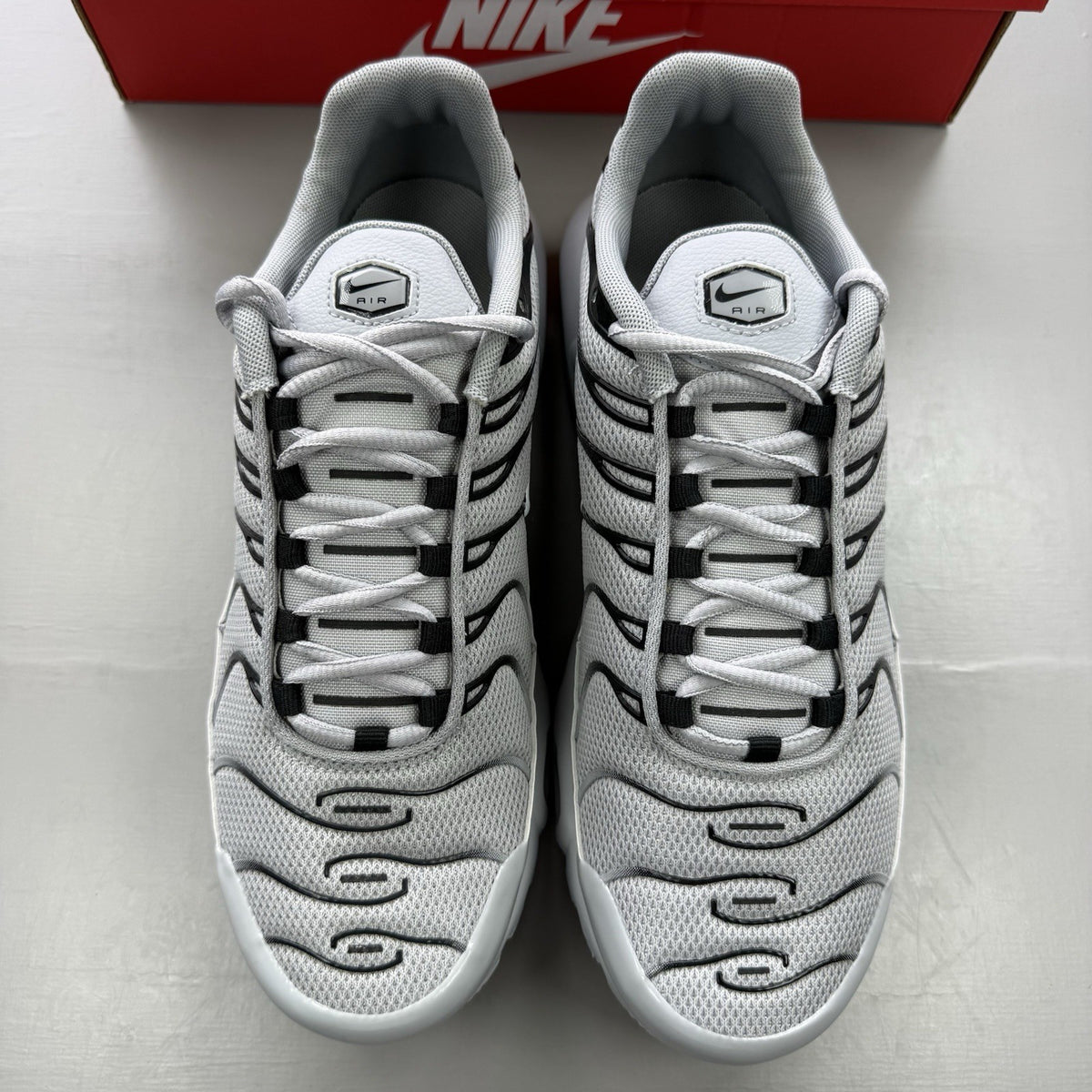Nike Air Max Plus TN grey trainers mismatched sizes with distinctive logo and sleek design.