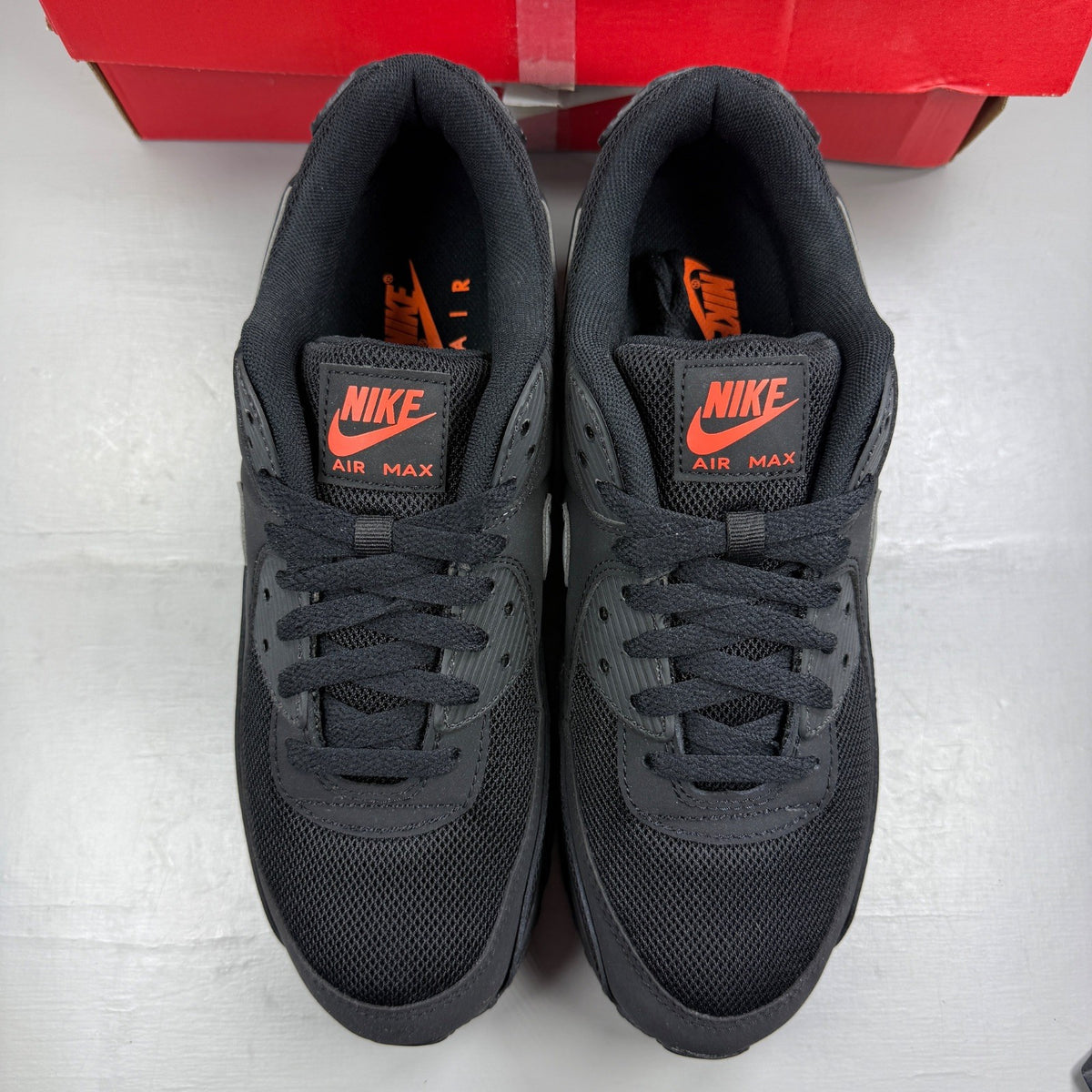 Nike Air Max 90 black sneakers with total orange accents and reflective silver details.