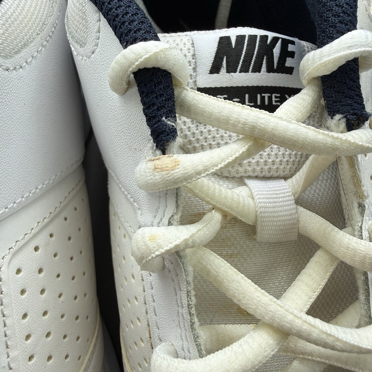 Nike T-Lite XI white trainers with obsidian and black accents, featuring a sleek design.