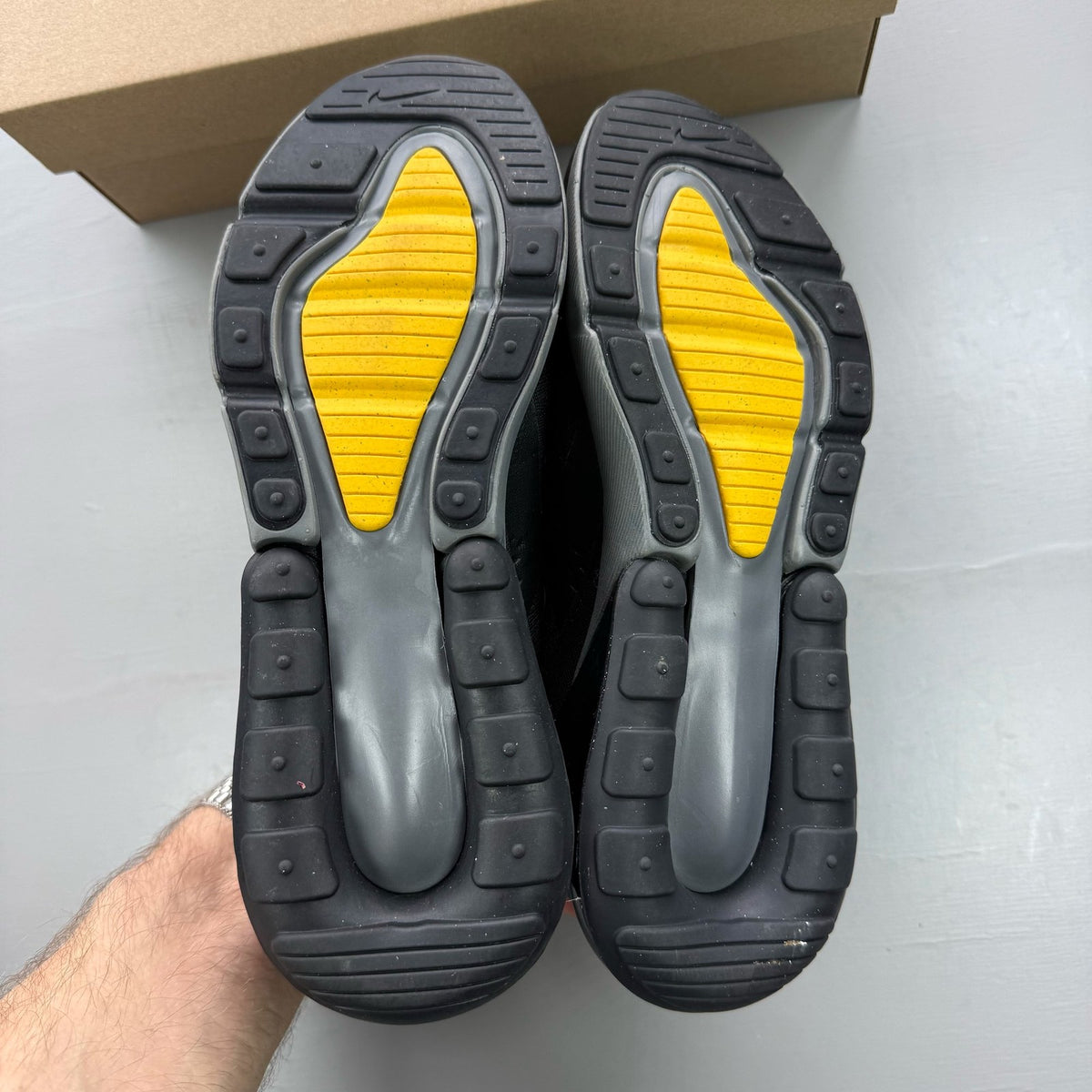 Nike black Air Max 270 trainers with grey and university gold accents, logo on tongue.