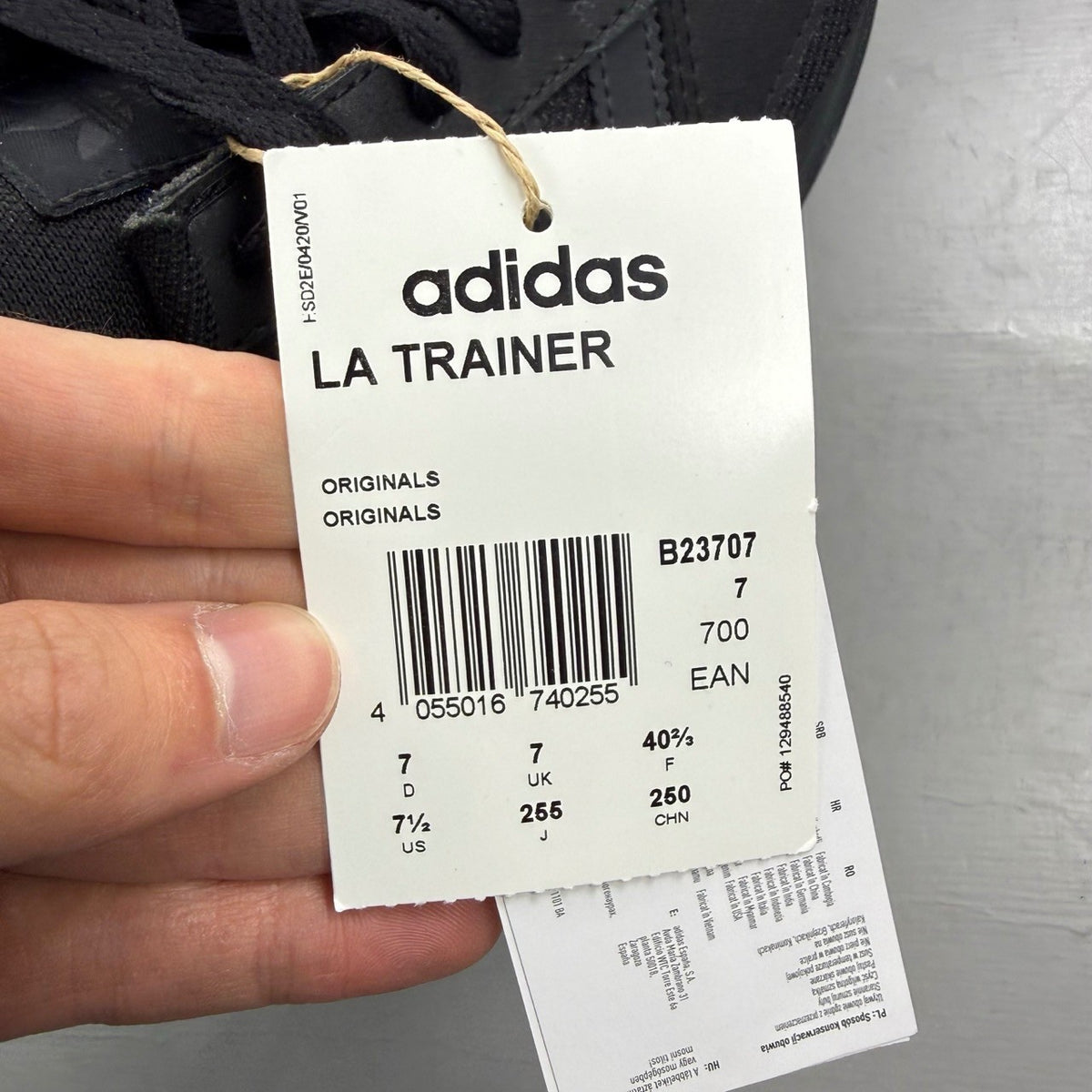Adidas black deck shoes with three stripes logo and textured upper.