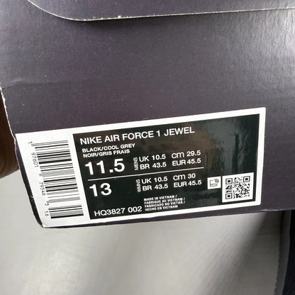 Nike Air Force 1 black trainers with cool grey accents and jewel detailing.